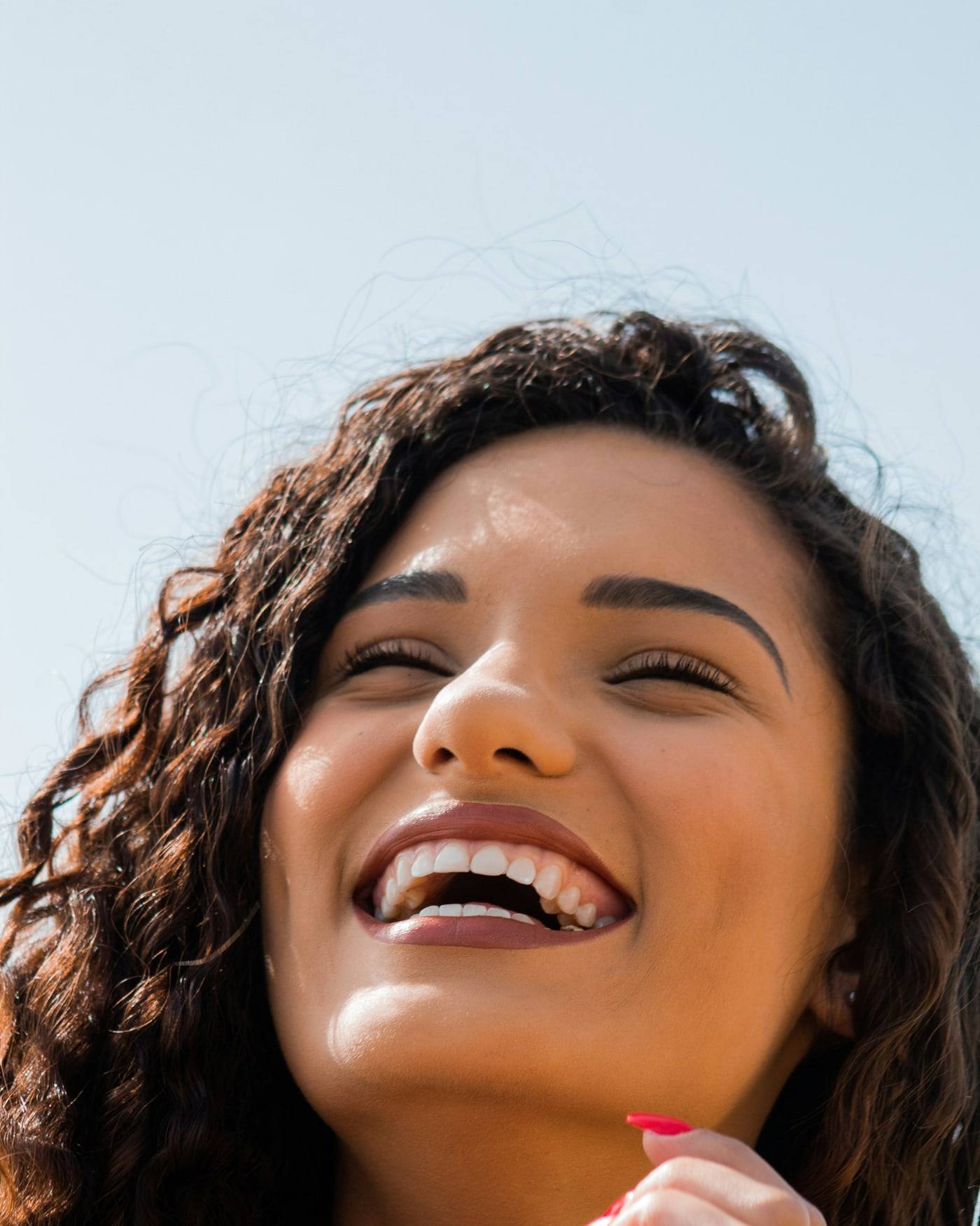 Mujer riendo con una sonrisa amplia y luminosa
